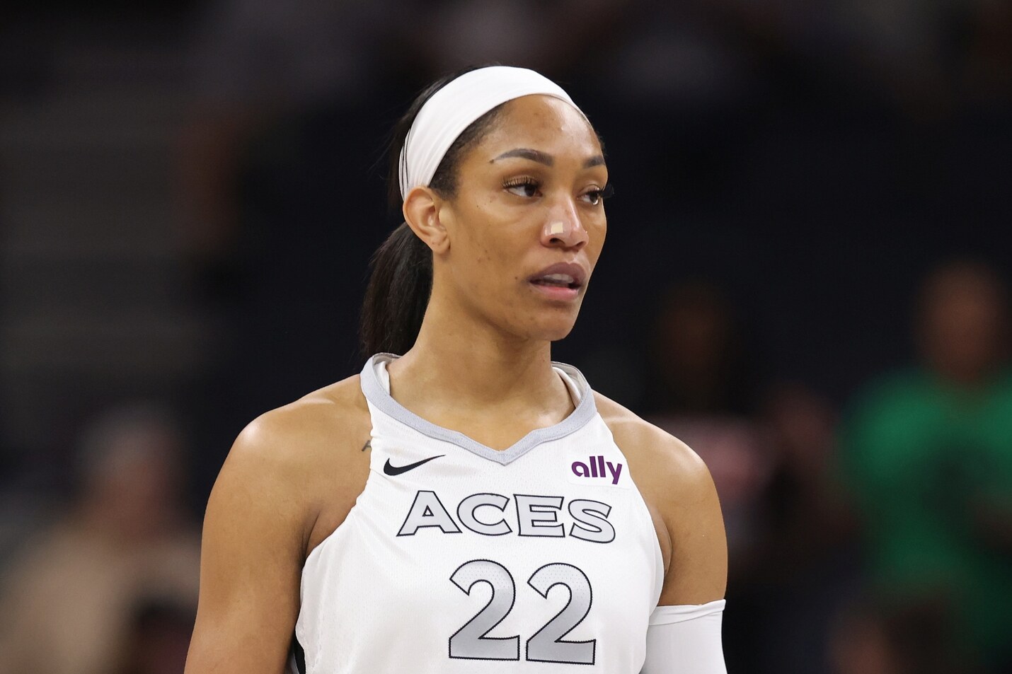 A'ja Wilson in a white Las Vegas Aces uniform, number 22, looking off to the side during a game