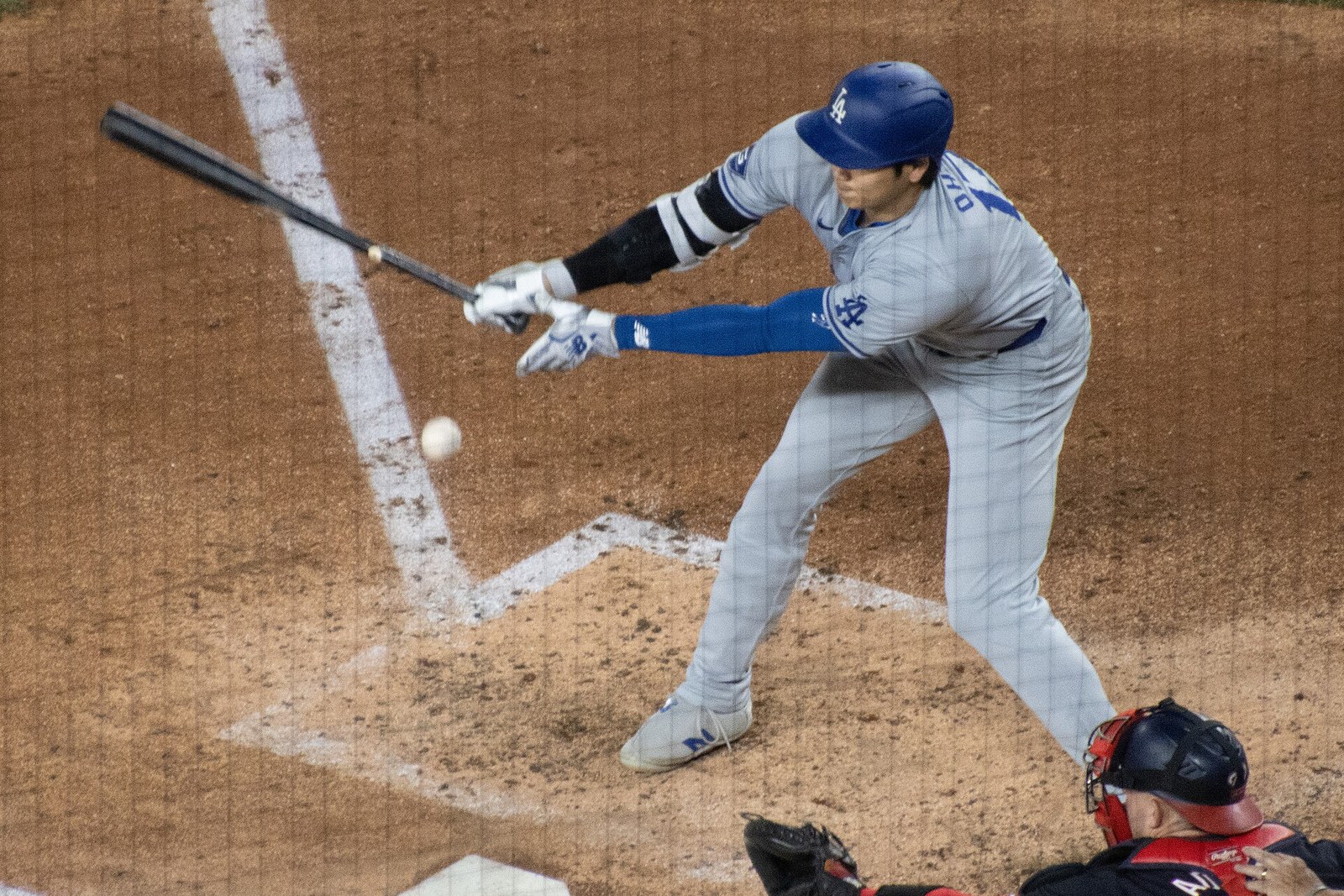 Shohei Ohtani mid-swing at bat in a gray Los Angeles Dodgers road jersey